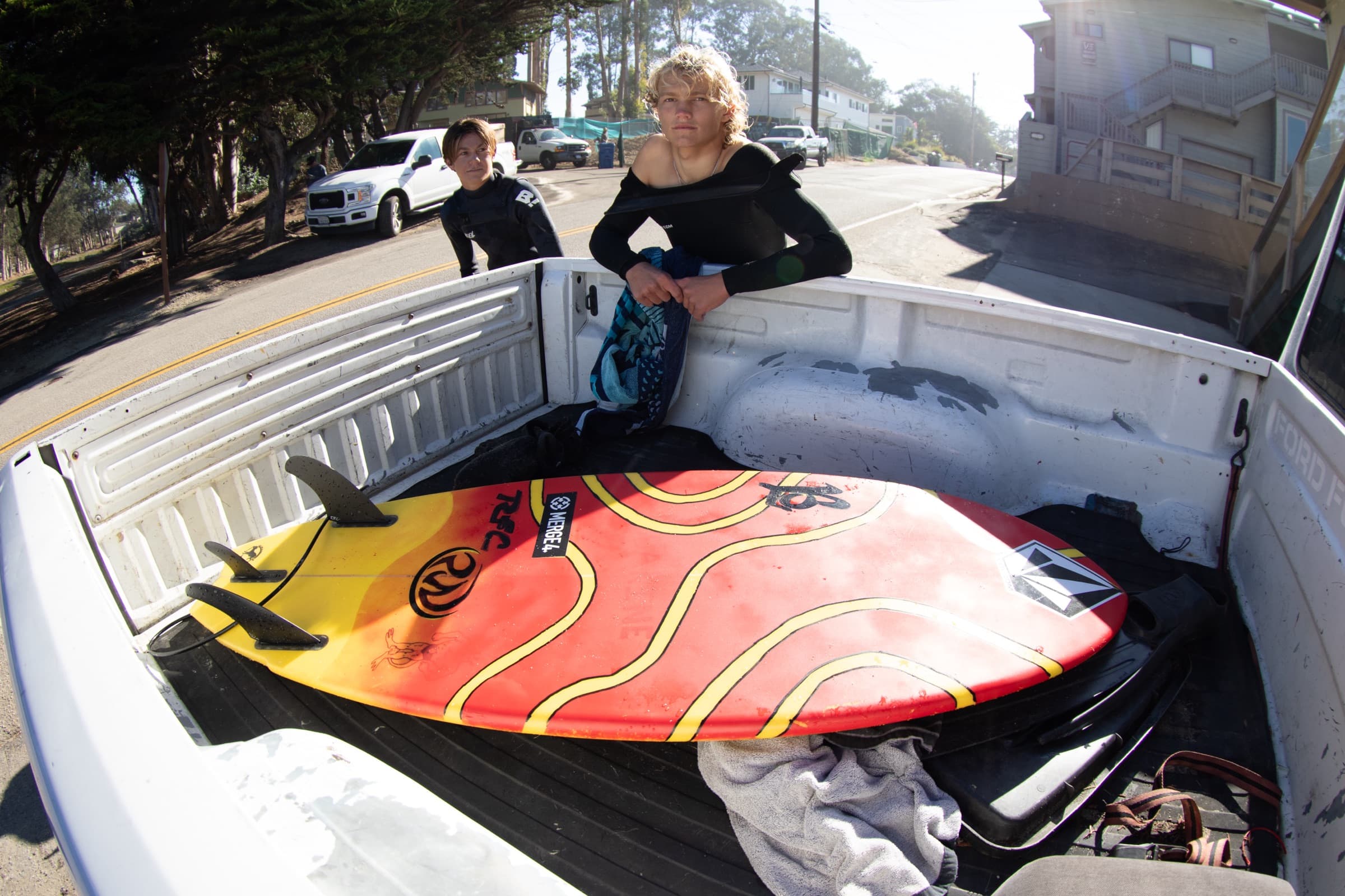 A surfboard in the back of a pickup after a session in Santa Cruz